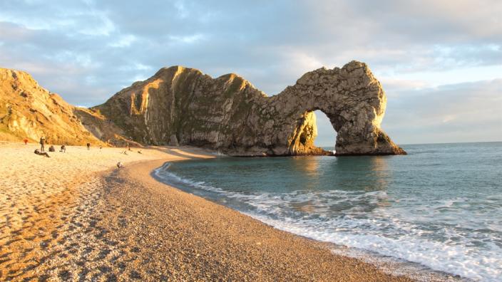 Durdle Door limestone arch and beach at sunset, Dorset